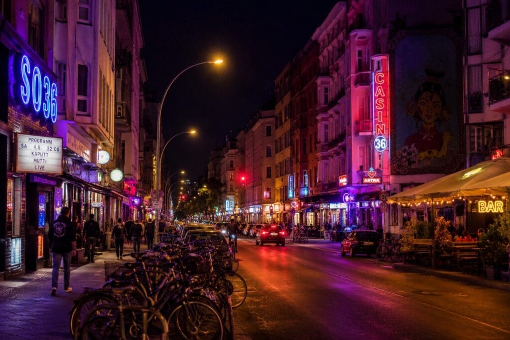 Kreuzberg la nuit, avec néons, vélos et passants à distance