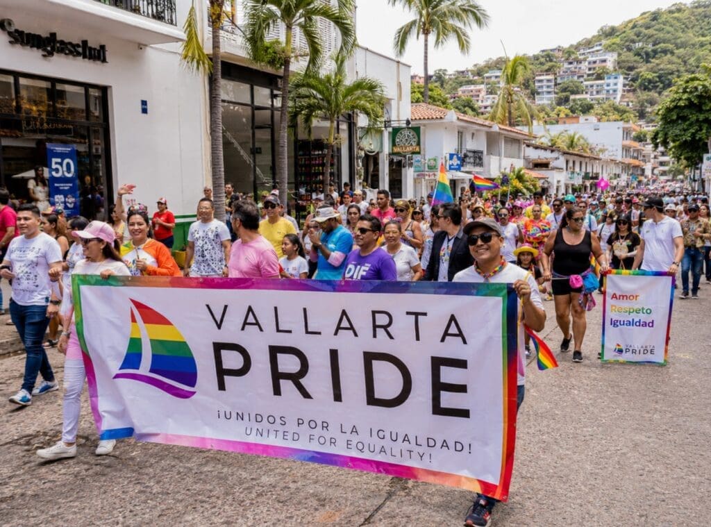 Vallarta Pride parade passing through the city, with community organizations, families, and rainbow flags
