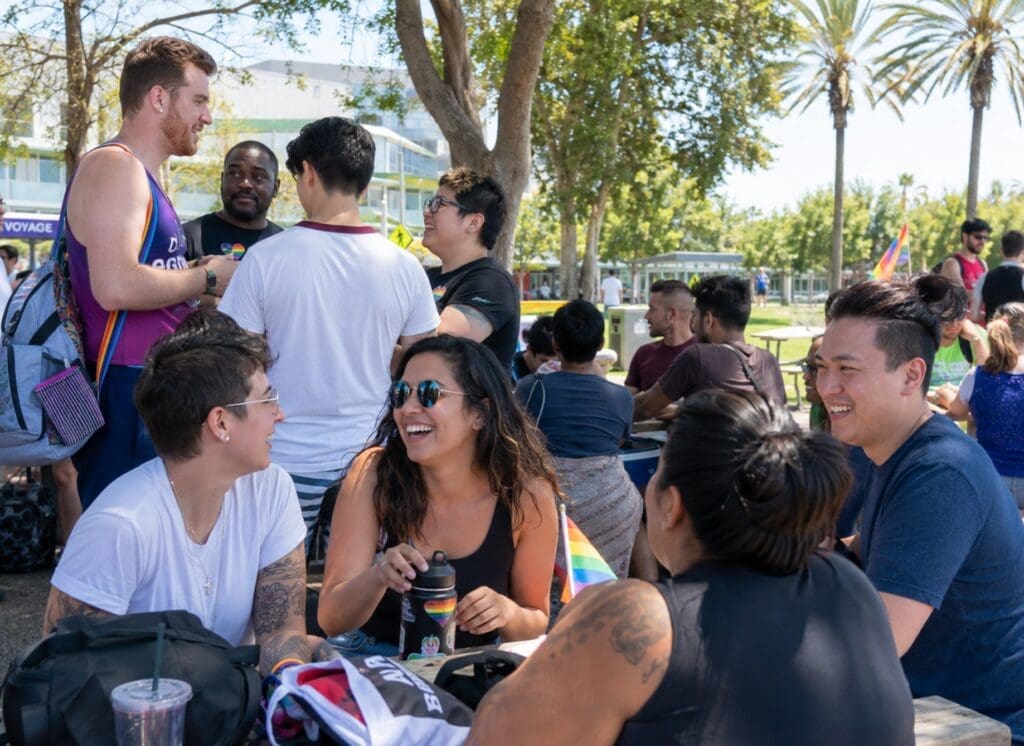 a documentary-style image of LGBTQ+ South Bay residents at a community event, sports league, or outdoor gathering