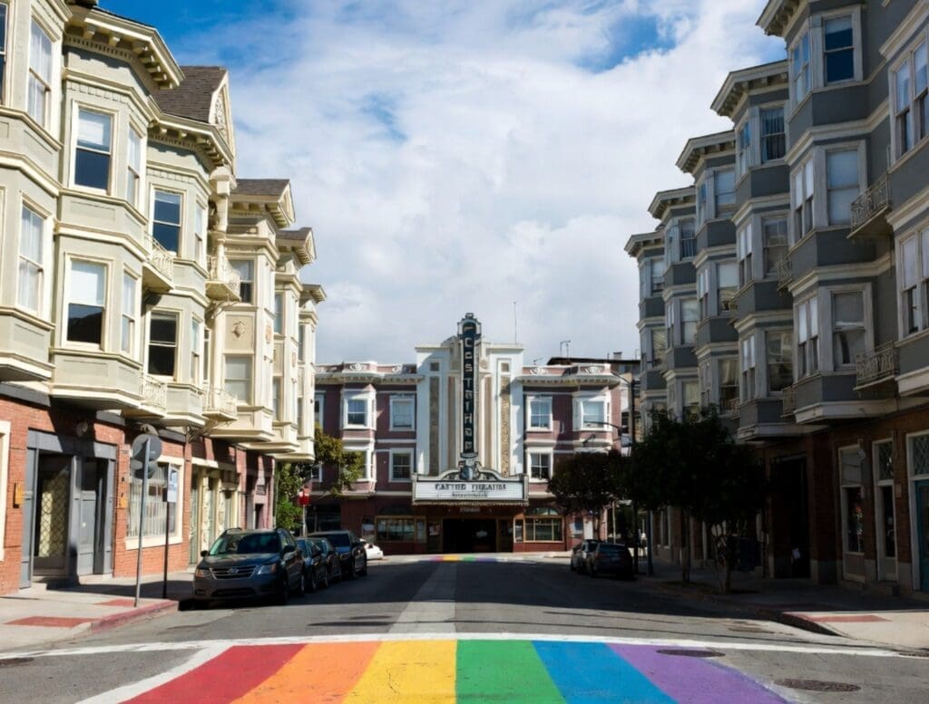 a photograph of the Castro’s rainbow crosswalks, Victorian buildings, and the Castro Theatre marquee