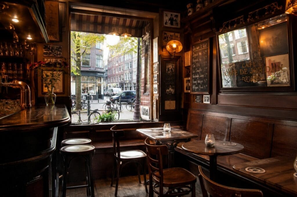 café brun amstellodamois, avec bois sombre, lumière douce et tables près de la fenêtre