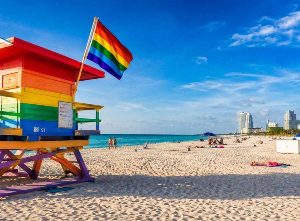 photograph of 12th Street Beach with rainbow flags and the ocean in the background