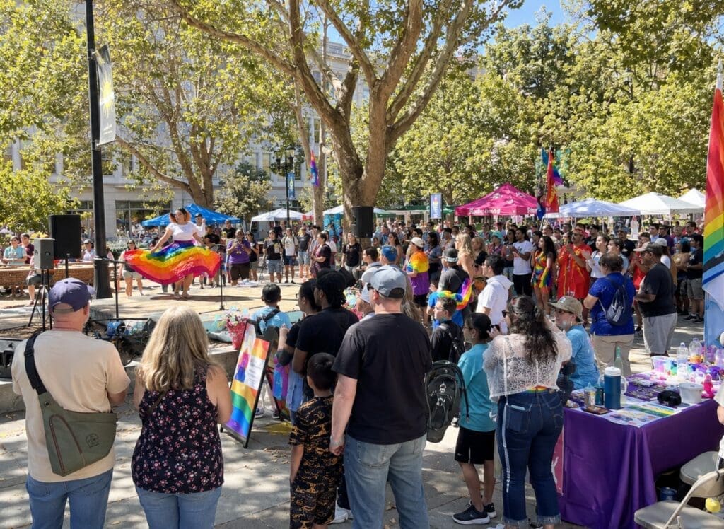 photo of Silicon Valley Pride in Plaza de César Chávez, showing performers, community groups, and families
