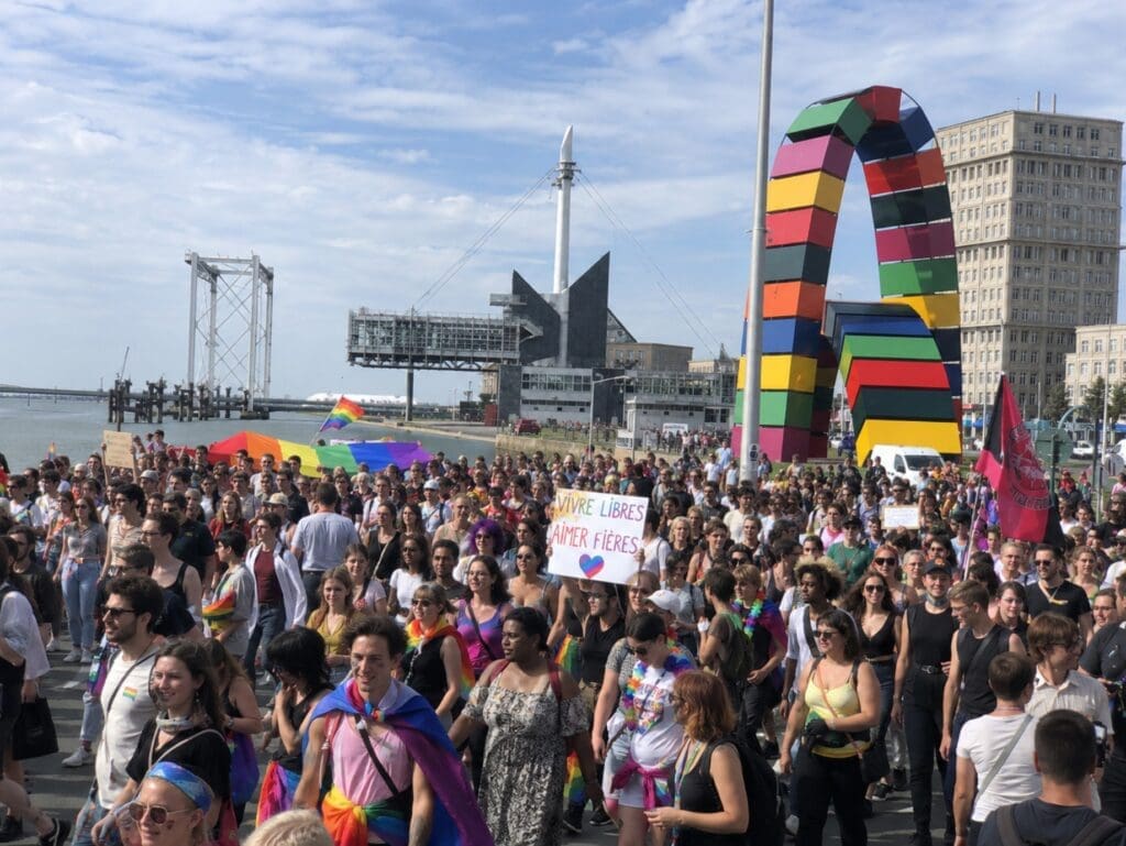 photographie de la Marche des Fiertés passant devant l’architecture portuaire (Le Havre)