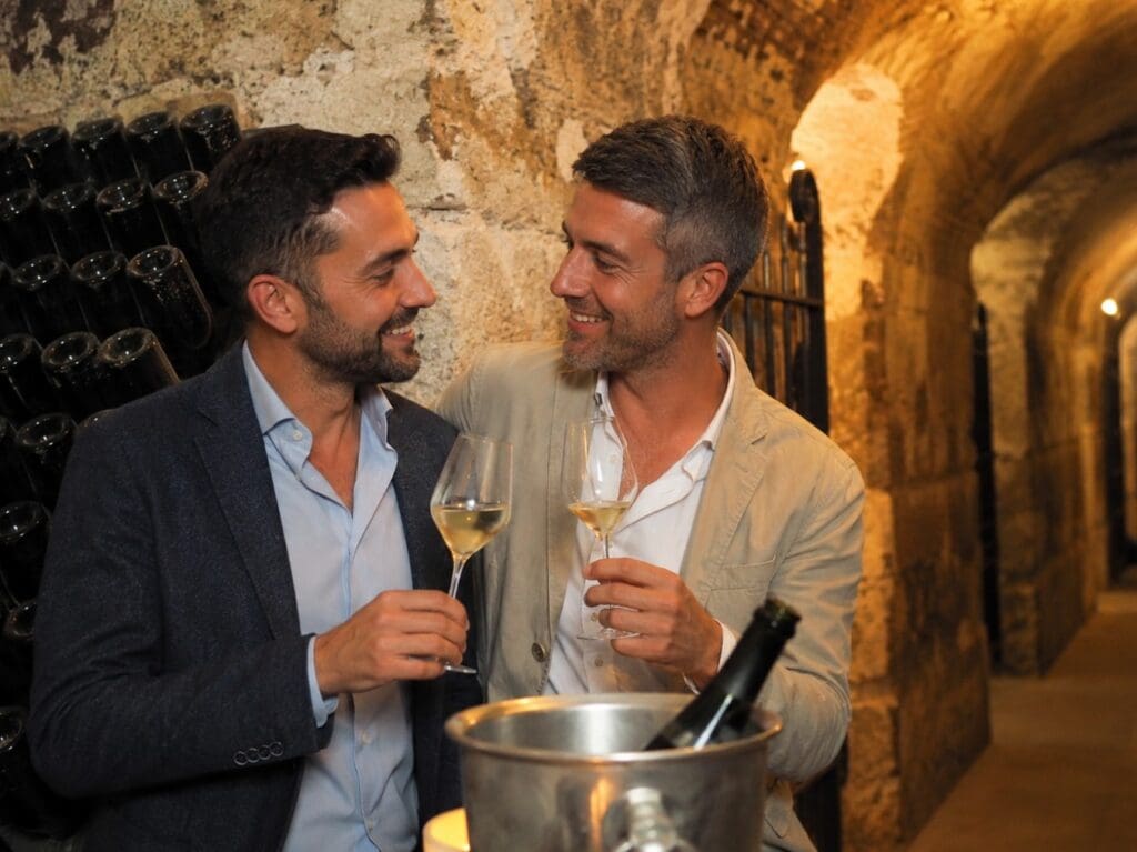 photographie d’un couple dégustant du Champagne dans une cave historique