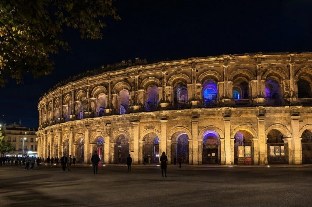 photographie nocturne des Arènes pendant un concert, prise depuis l’espace public (Nîmes)