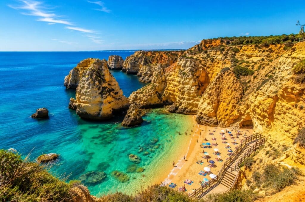 uma fotografia das falésias douradas e das águas turquesa da costa algarvia