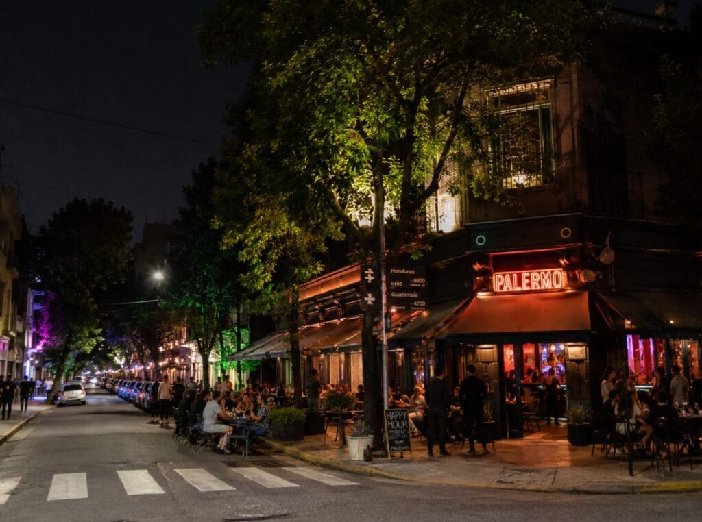 una fotografía de una esquina animada de Palermo Soho por la noche, con luces de bares
