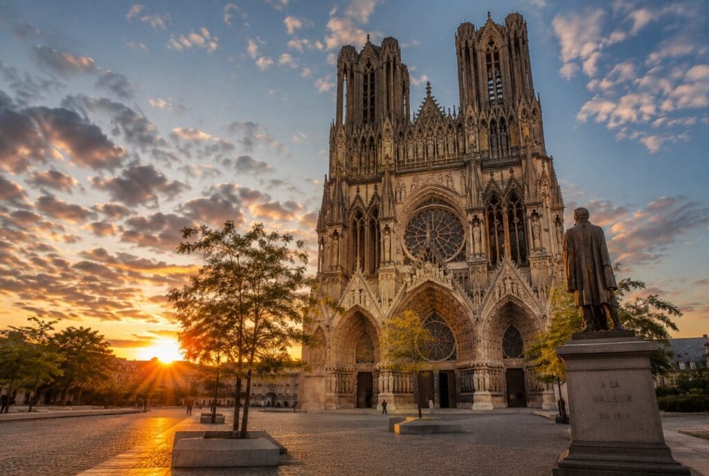 une photo originale et lumineuse du parvis de la cathédrale Notre-Dame de Reims au coucher du soleil