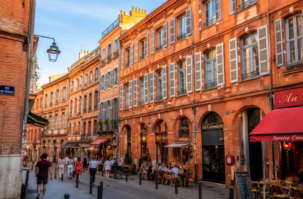 une photographie des façades en briques roses du centre historique de Toulouse